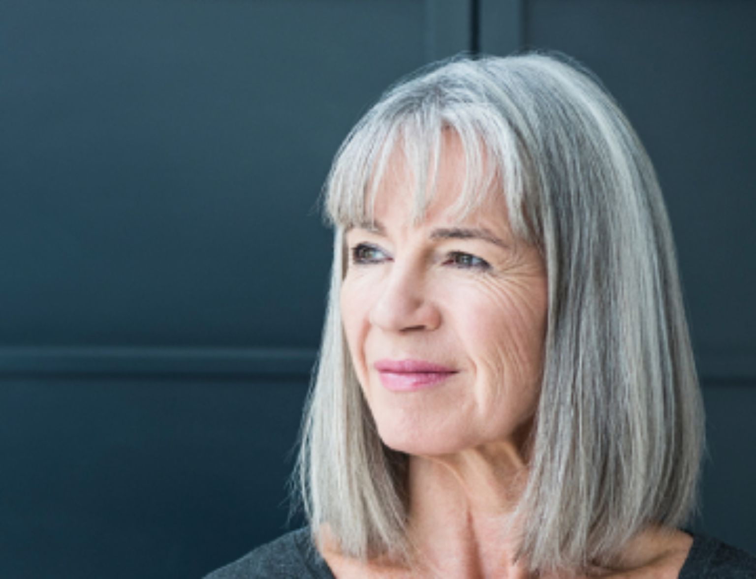 Blog Teaser - Frau vor dunklem Hintergrund aus dem Artikel Guthaben aus der Säule 3a: investieren oder ruhen lassen?