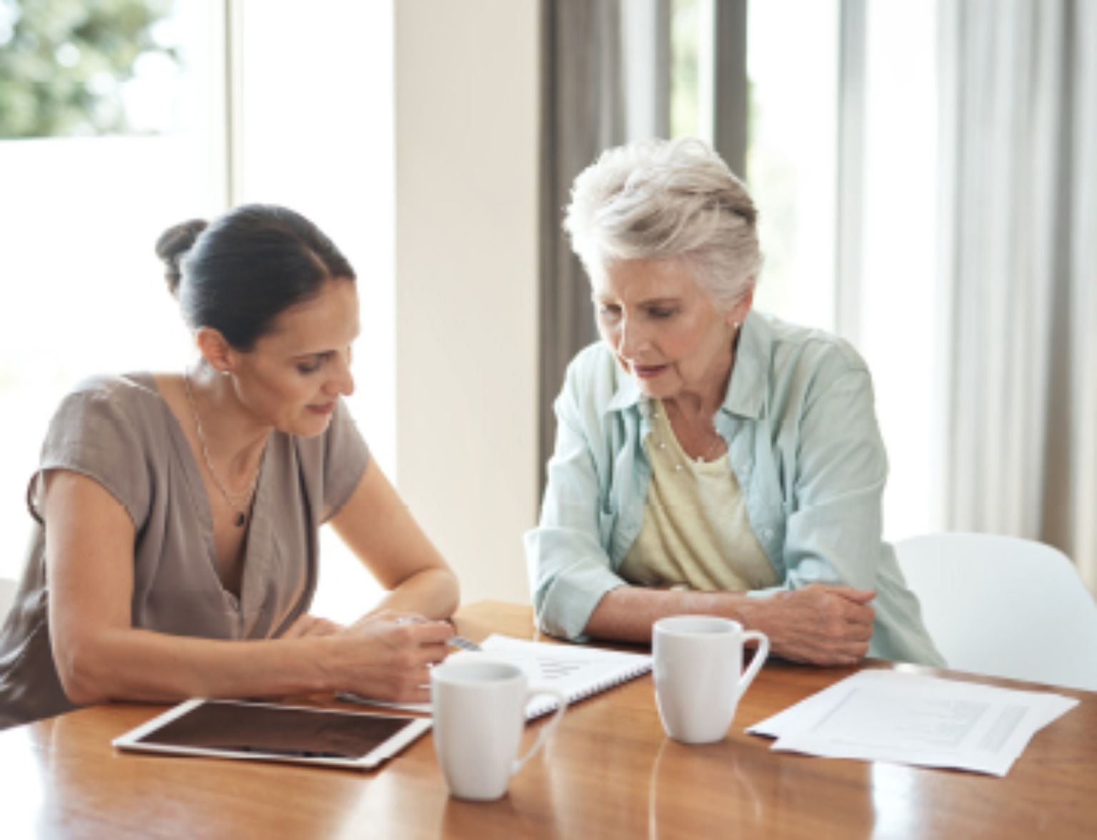 Blog Teaser - Eine junge Frau und eine alte Frau ein einem Gespräch aus dem Artikel Steuern bei Erbschaft und Schenkung – Antworten auf die wichtigsten Fragen