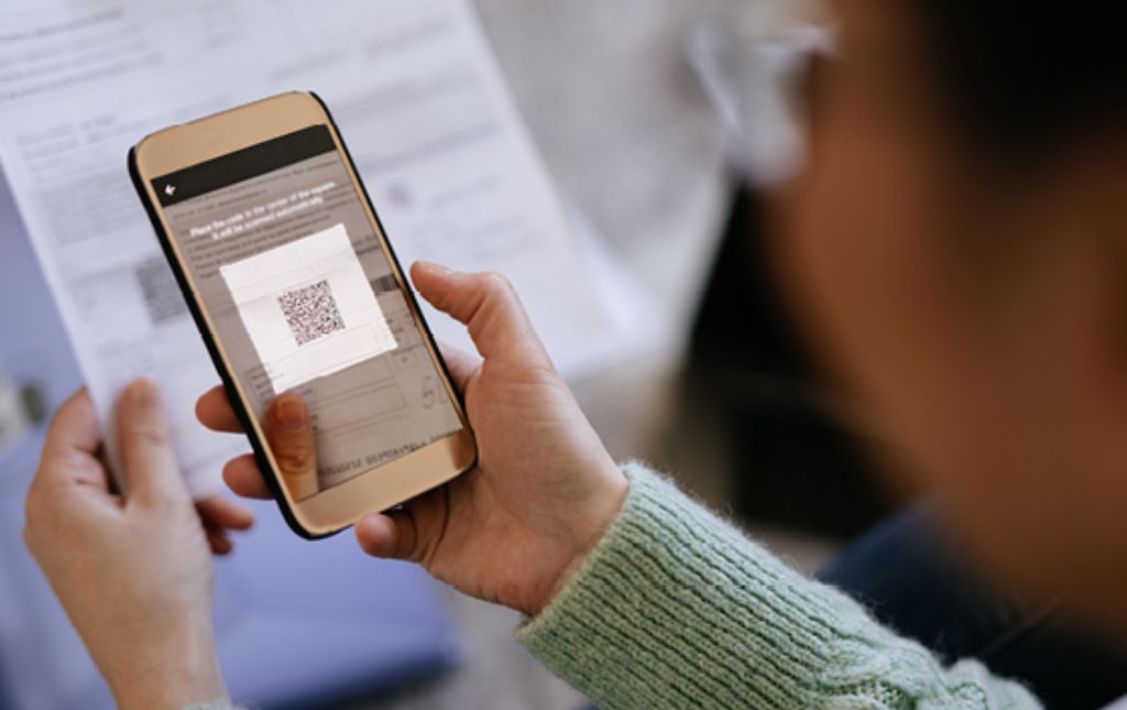 Info Teaser - Frau scannt eine QR-Rechnung