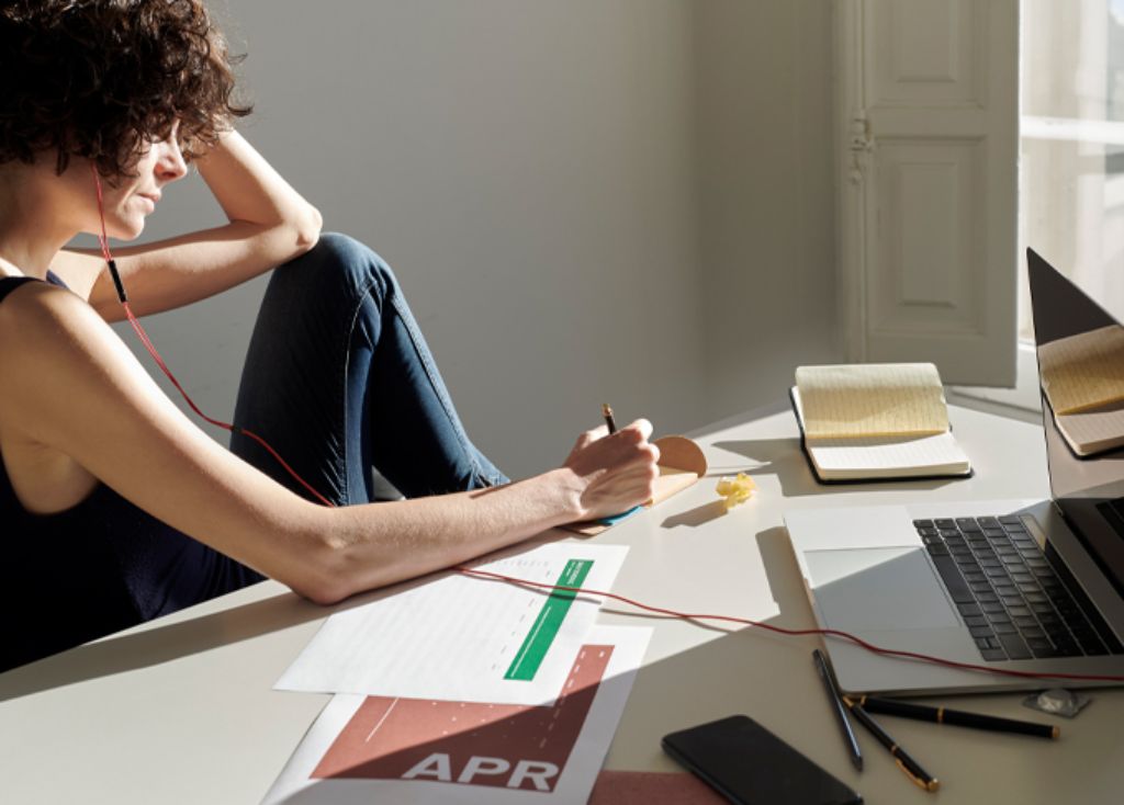 Info Teaser - Frau hört Musik und schreibt etwas